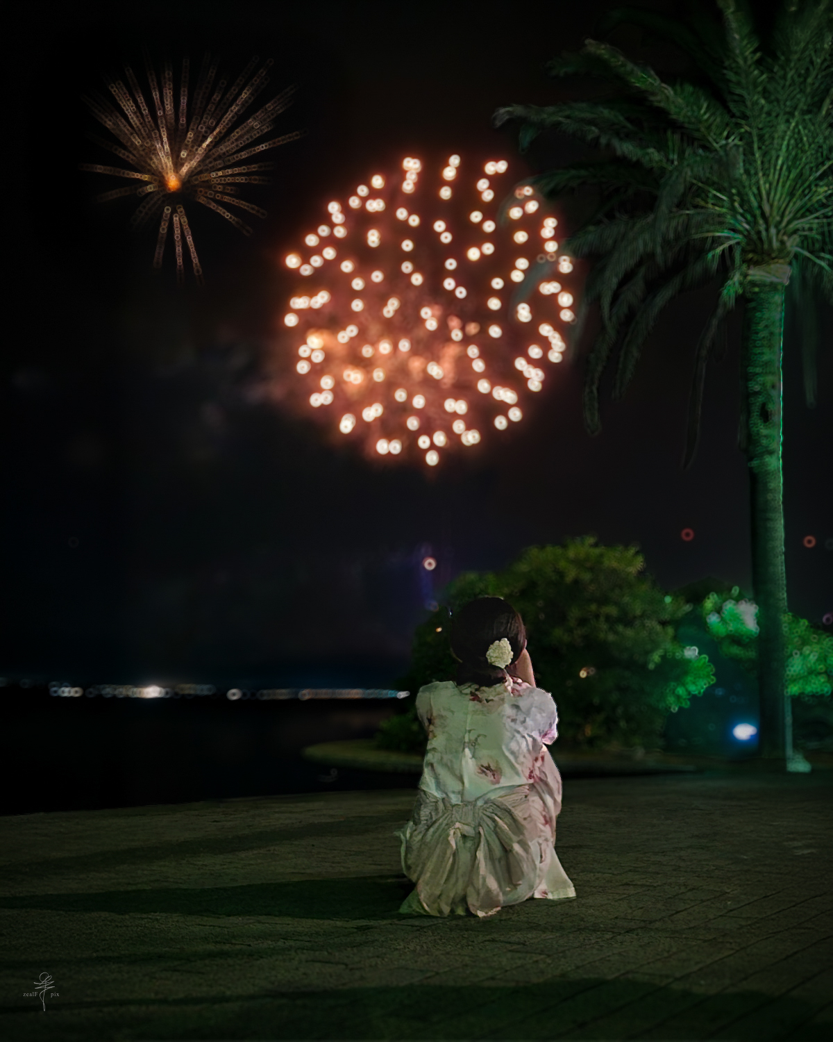 Person in a yukata watching fireworks beside the water